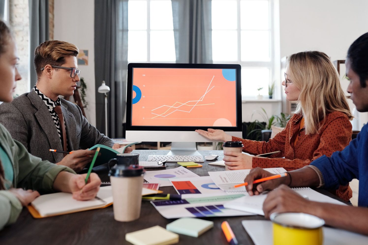 Equipo de trabajo en una reunión revisando un gráfico en una pantalla