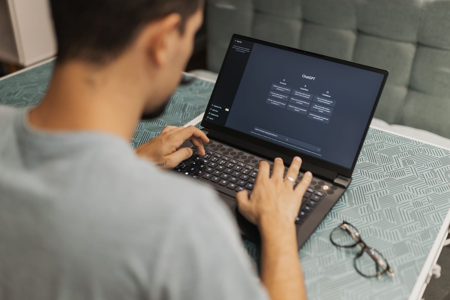 Persona escribe una consulta en un asistente de inteligencia artificial desde su laptop