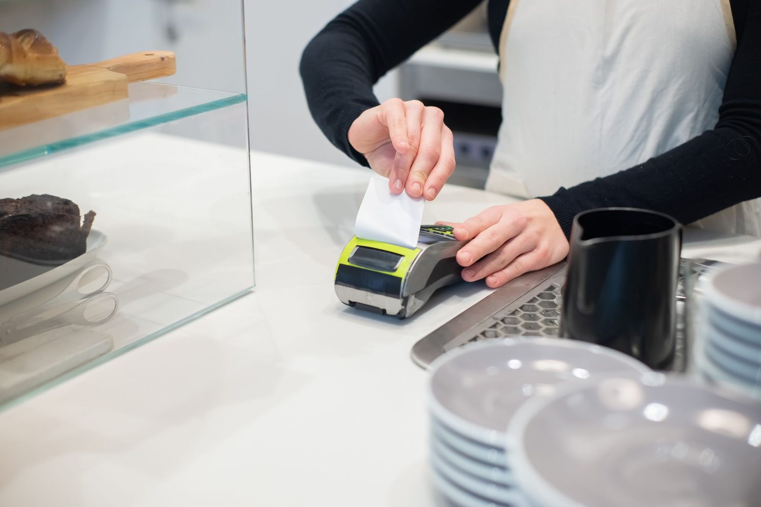 Empleada de un comercio retira el comprobante impreso por el terminal de pago