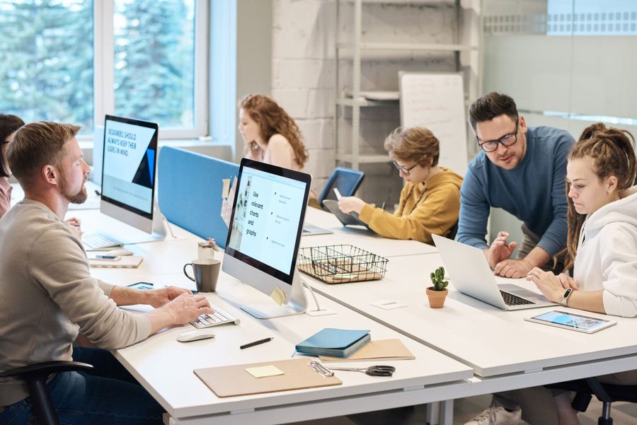 Equipo de una empresa trabajando en computadoras en una oficina abierta